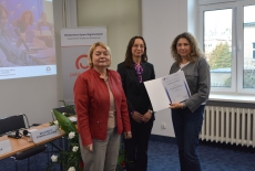 Uczestnik pozuje z dyplomem, obok pani z MSZ i dyrektor KSAP