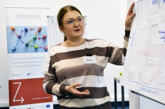 uczestniczka stoi przy flipczarcie, w tle baner projektu